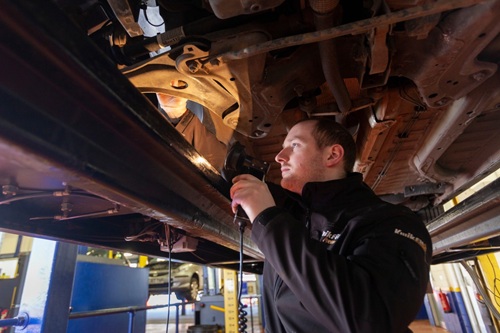 Mechanic-reviewing-the-underbody-of-a car